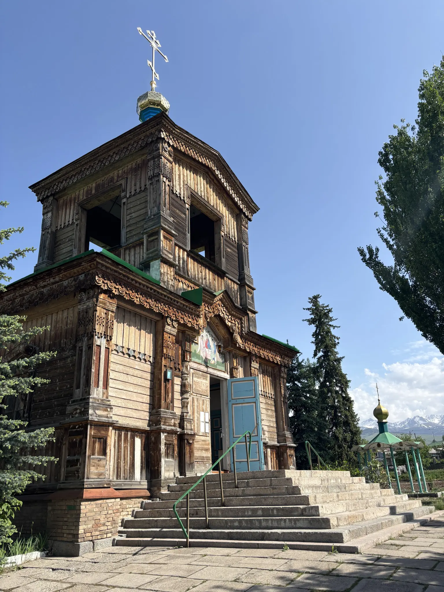 wooden orthodox church with blue door and golden dome in Kyrgyzstan